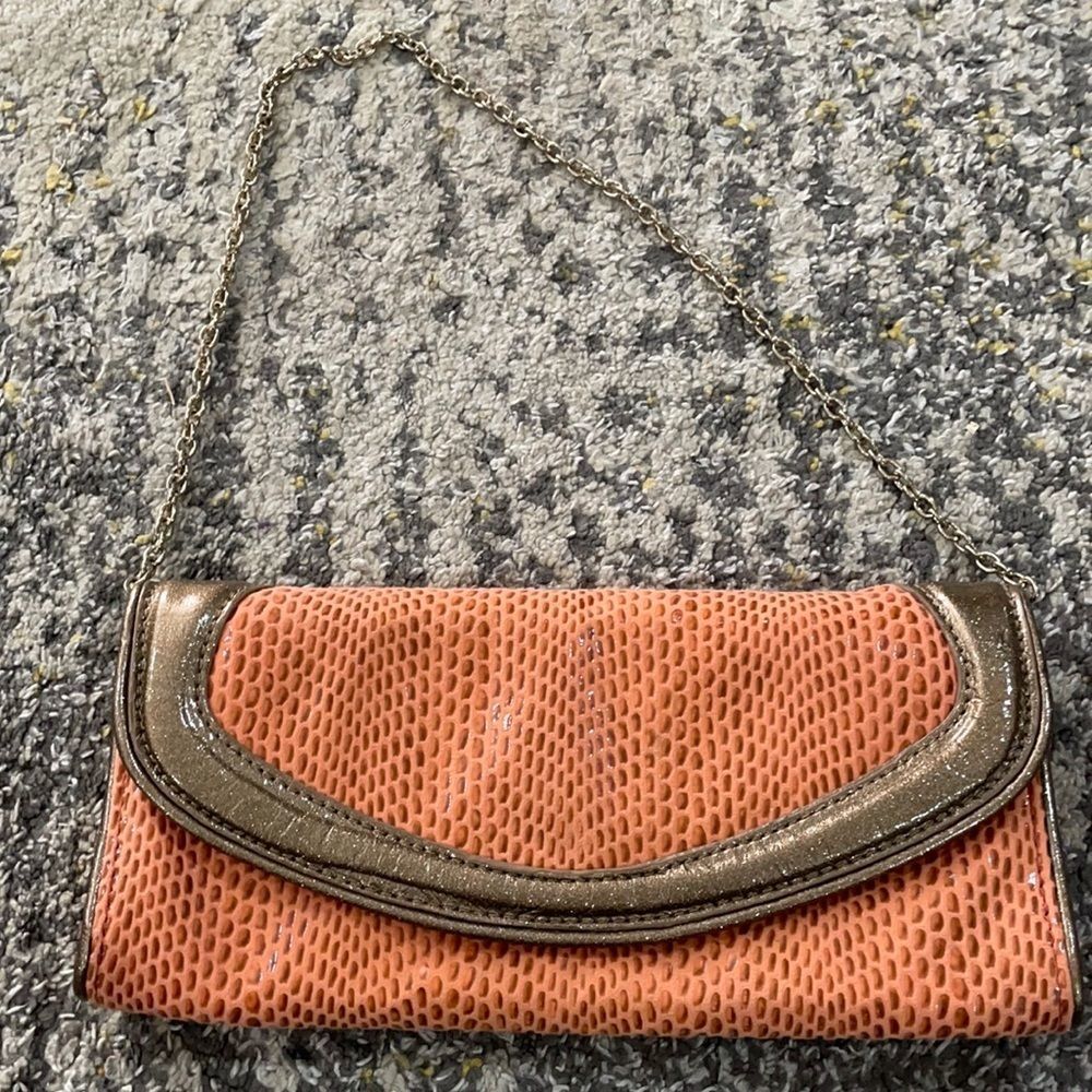 Sondra Robert’s orange snake skin fabric with faux metallic gold leather clutch
